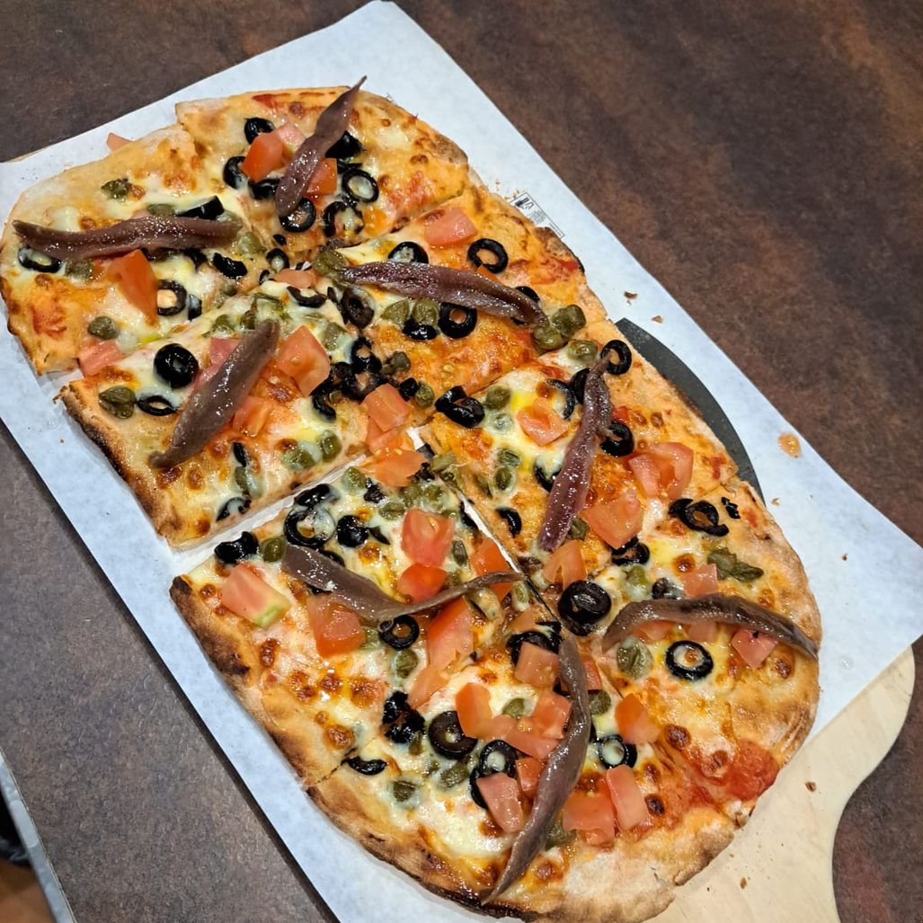 Pizza con salmón, anchoa y aceitunas negras
