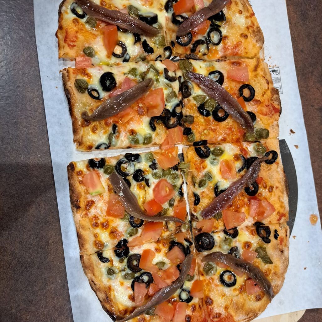 Pizza con salmón, anchoa y aceitunas negras